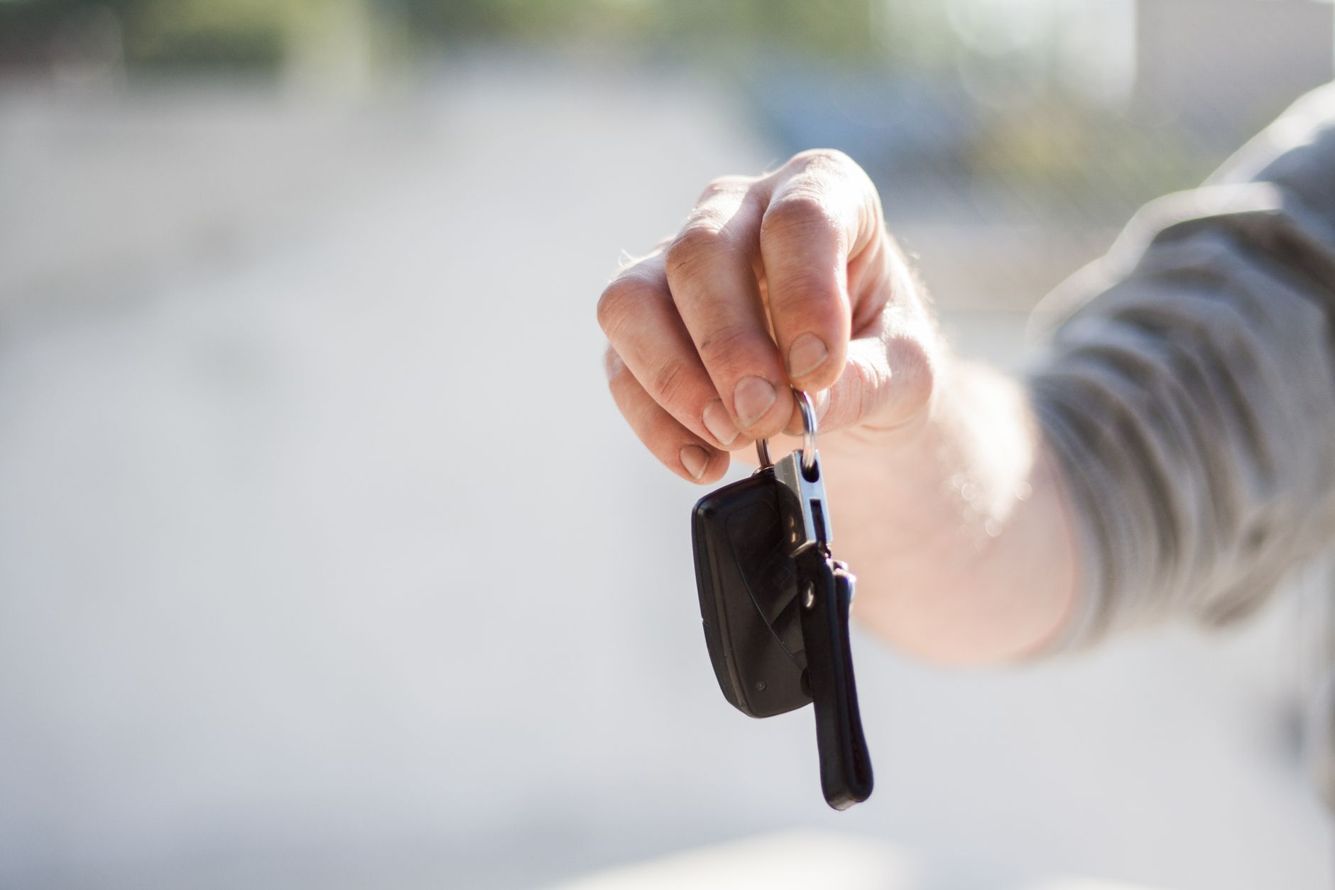 Hand holding out a set of car keys
