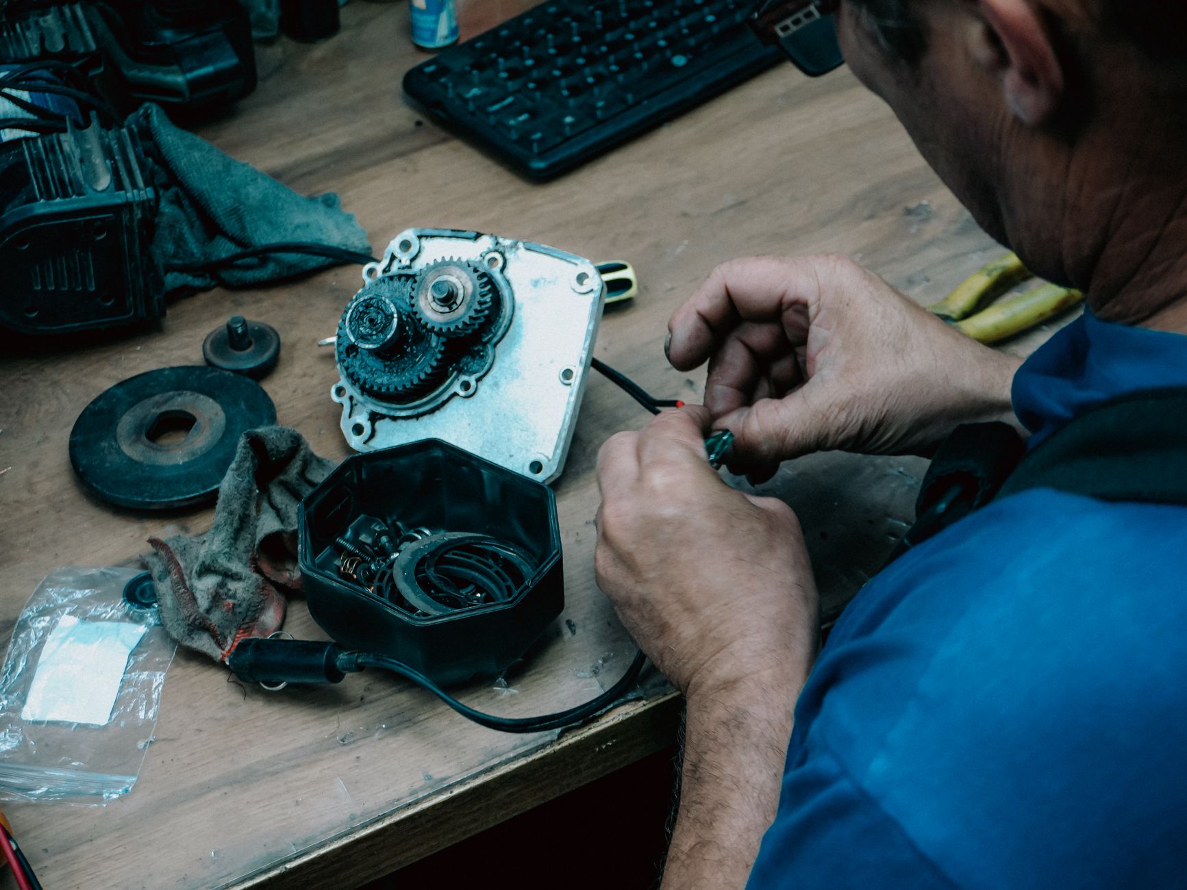 Hands reassembling gearbox parts on a workbench