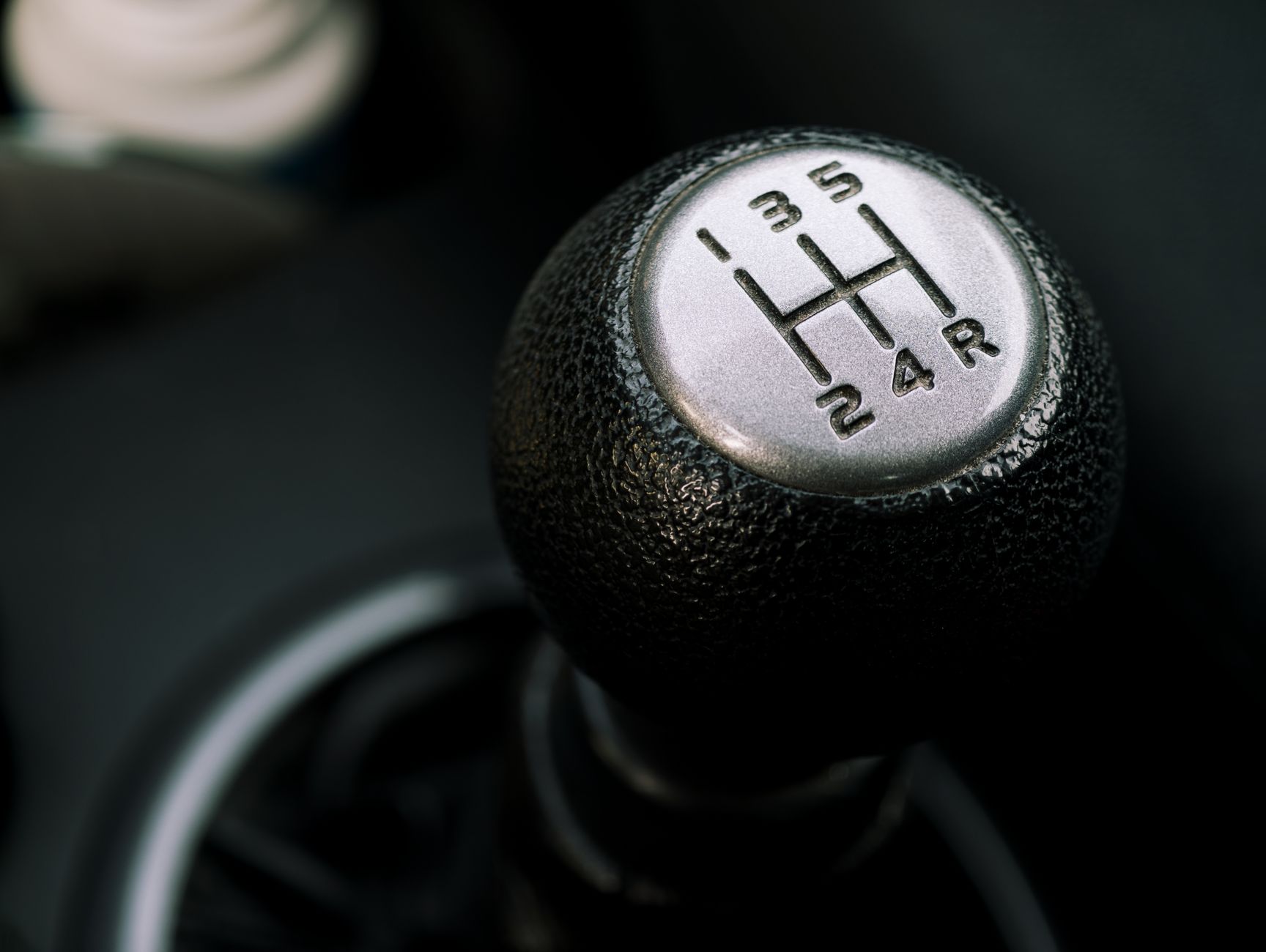 Manual gear shift knob showing a five-speed pattern