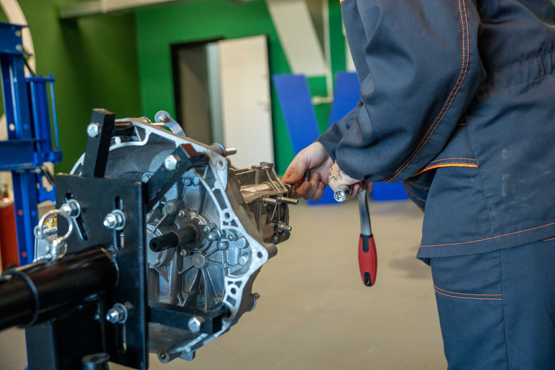 Mechanic repairing an automatic transmission on a workbench