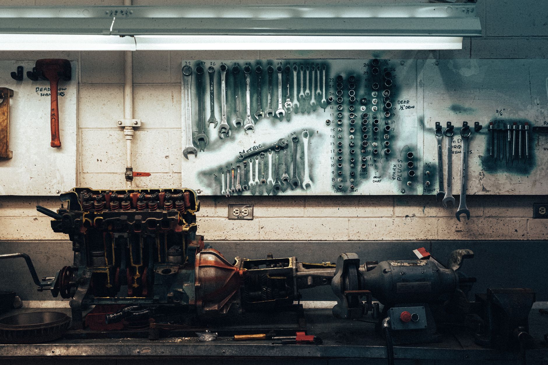 Organised wall of mechanic's tools above a workbench
