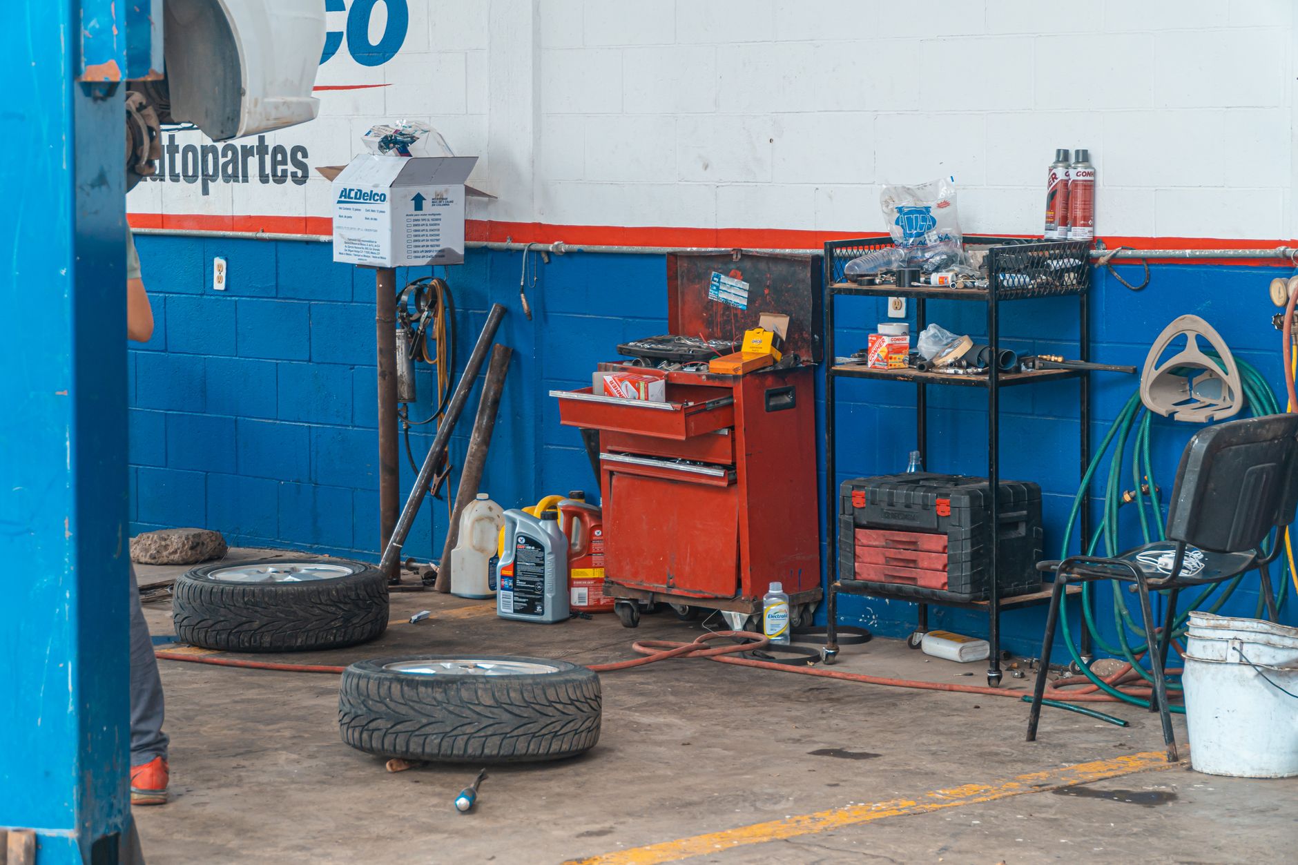 Repair bay with a red tool cart, shelves and tires on the floor