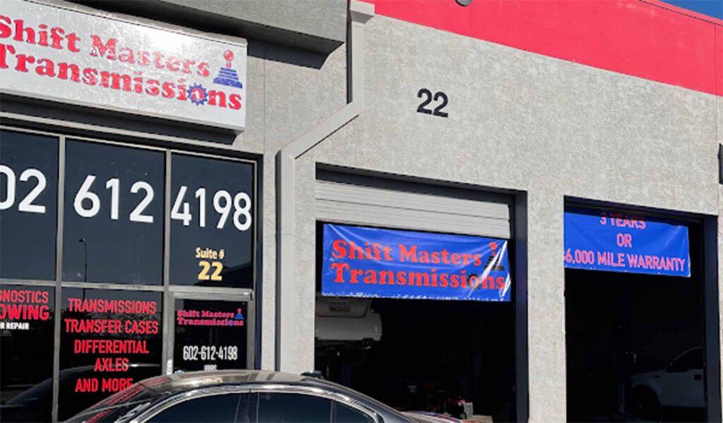 Exterior view of Shift Masters Transmissions garage in Phoenix AZ showing service entrance, signage, and parking area