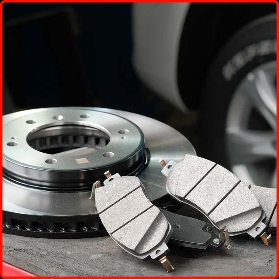 Mechanic replacing brake pads and inspecting rotors at Shift Masters Transmissions in Phoenix AZ