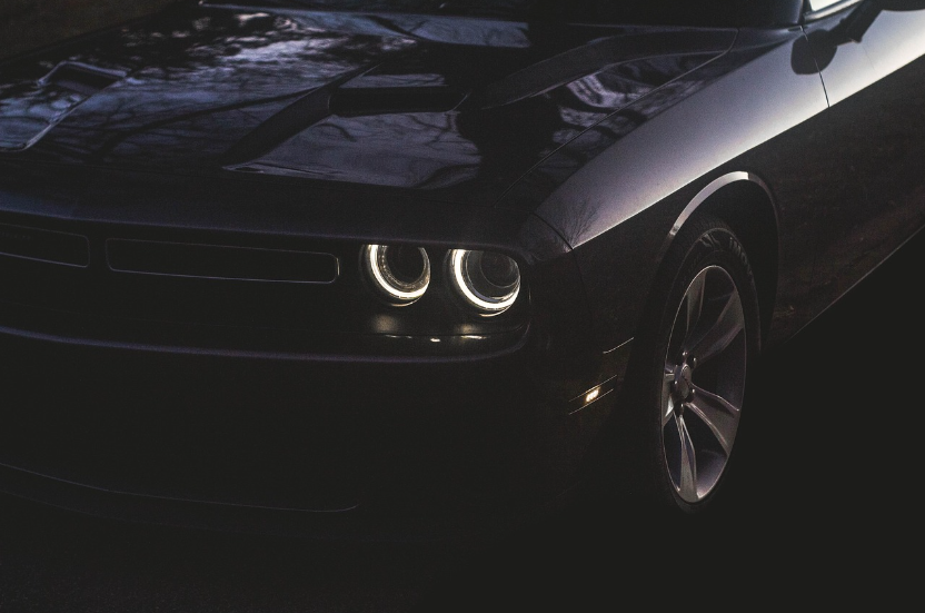 Black Dodge performance vehicle with illuminated halo headlights parked outside Shift Masters Transmissions in Phoenix, Arizona.