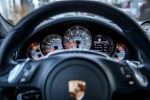 Porsche steering wheel with logo representing luxury vehicle transmission diagnostics at Shift Masters Transmissions Phoenix Arizona